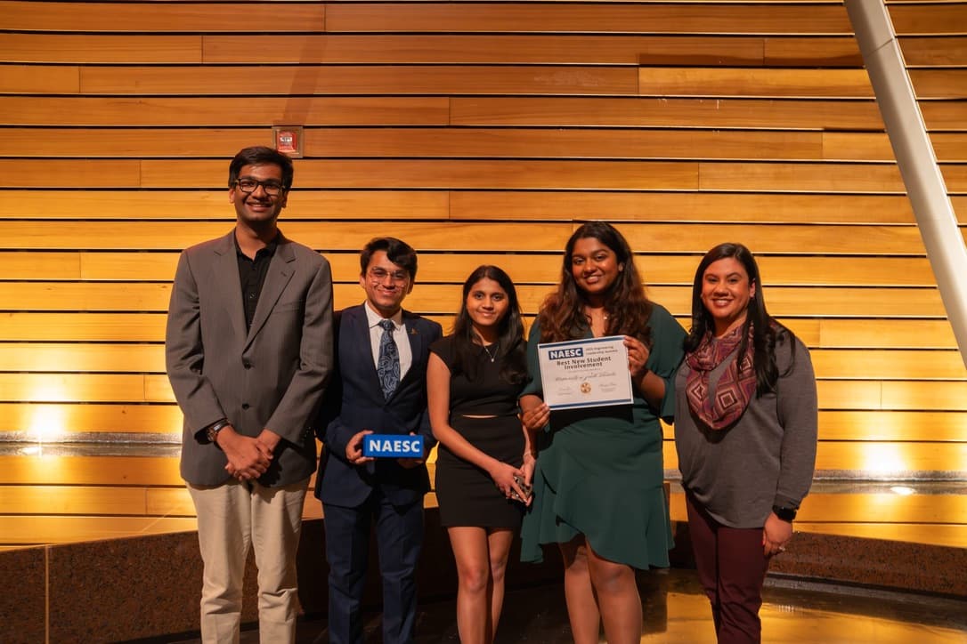 Stuti and fellow student leaders holding recognition plaques and a certificate