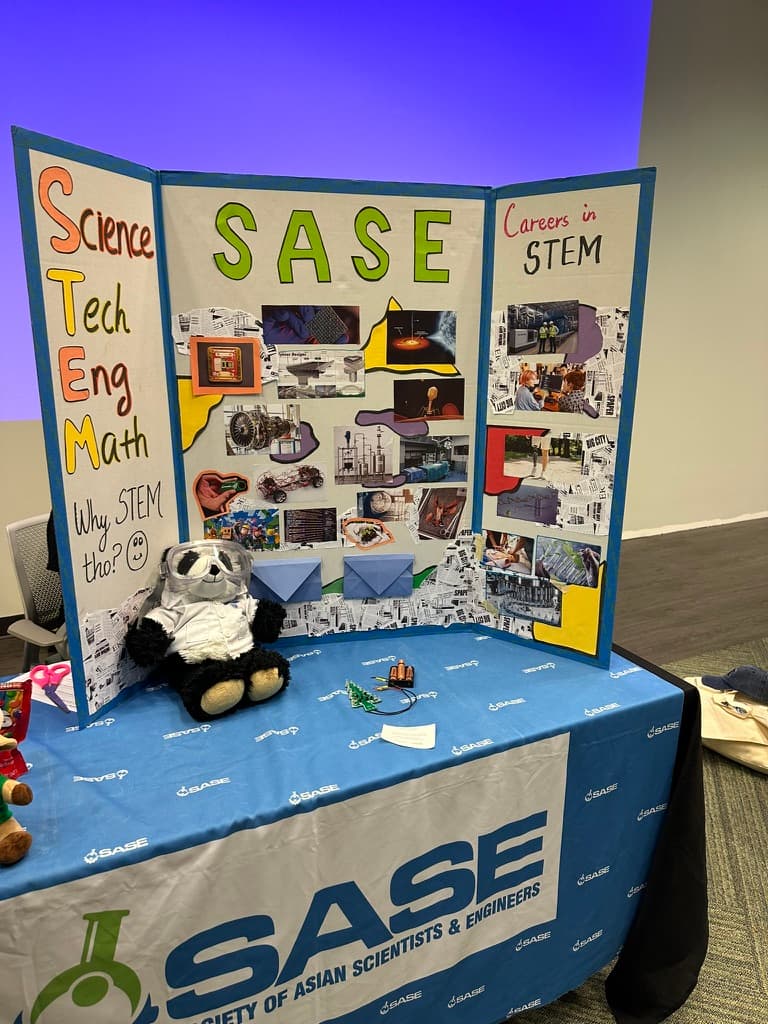 SASE outreach table with a display about science, technology, engineering, and mathematics